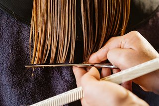 A hairdresser cutting a woman's hair